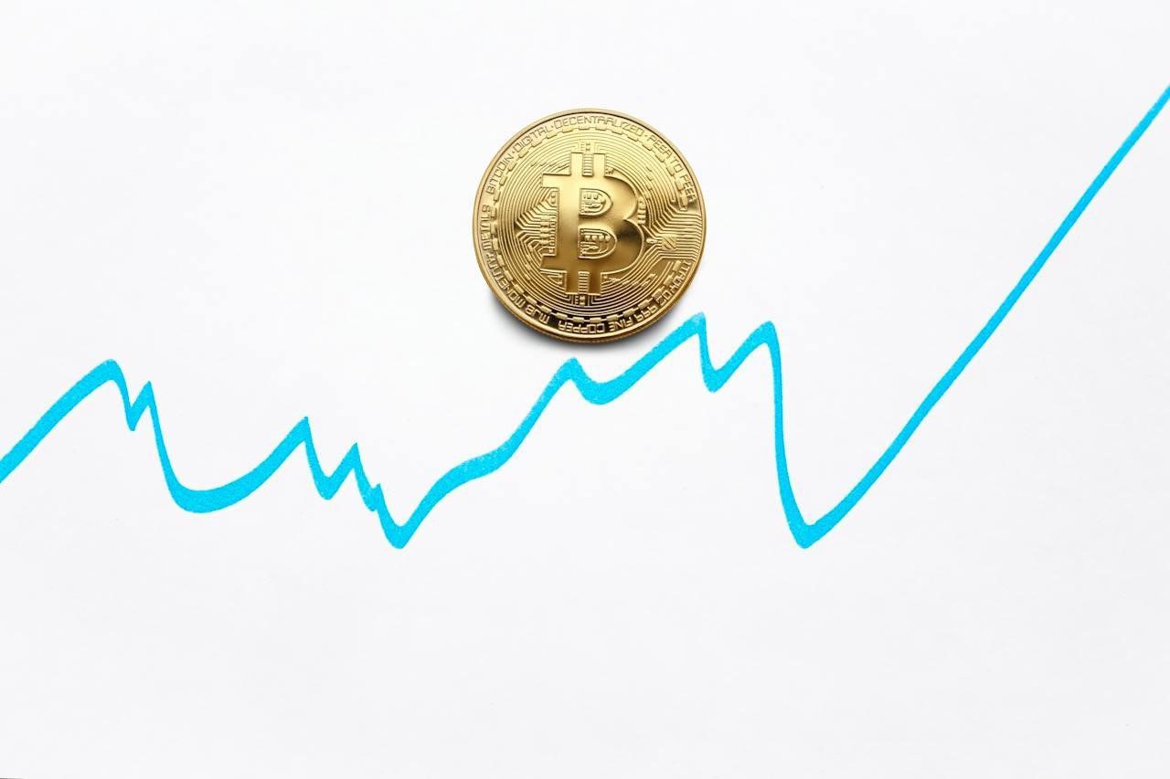 Turquoise graph with a golden coin with the bitcoin logo on it