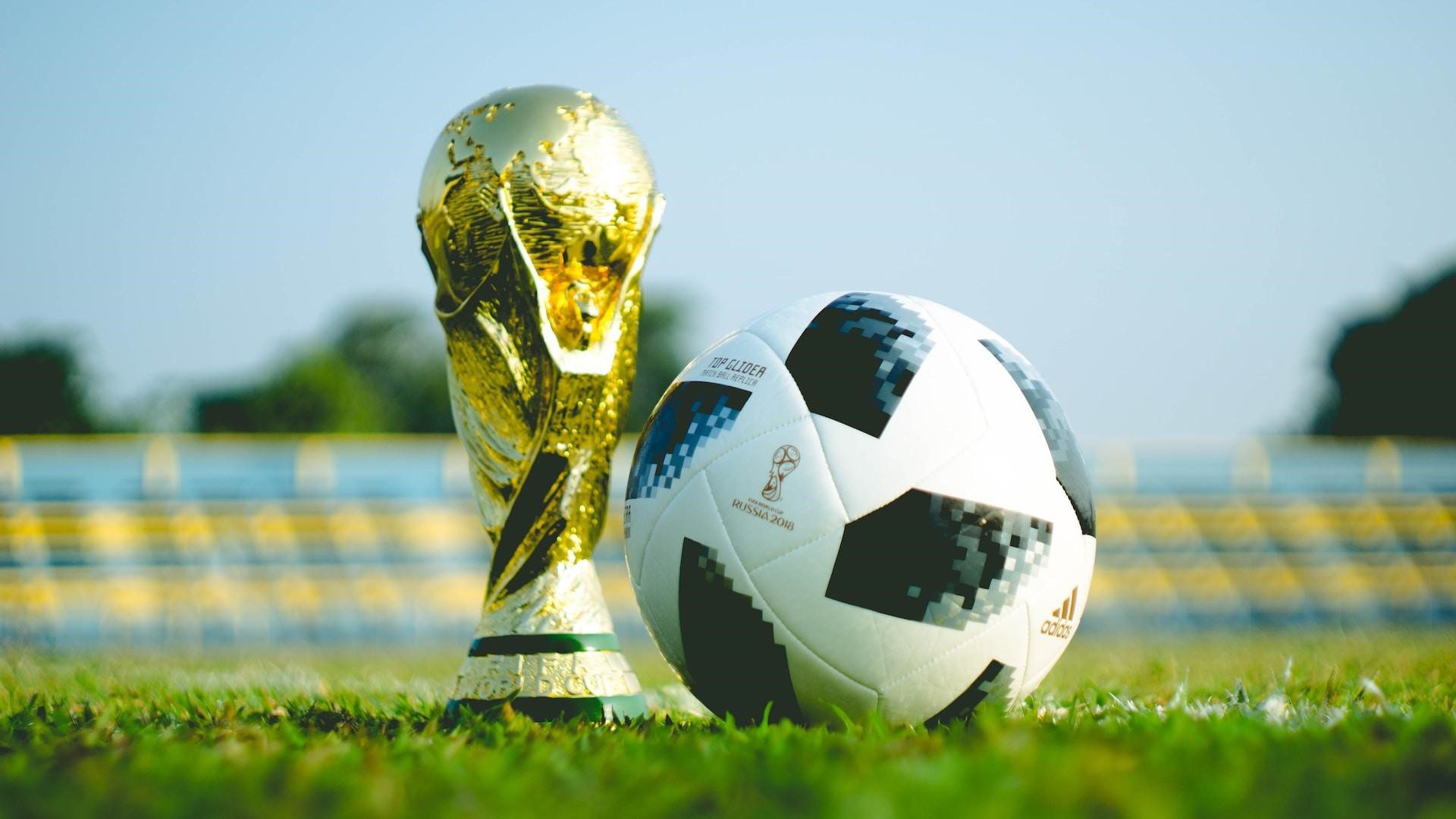 An image of the FIFA trophy and a football