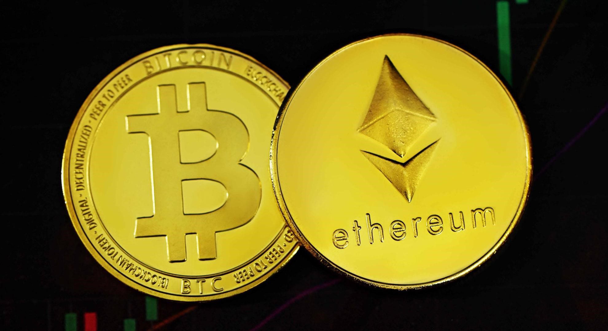 Two gold coins. One with the Bitcoin logo and one with the Ethereum logo.